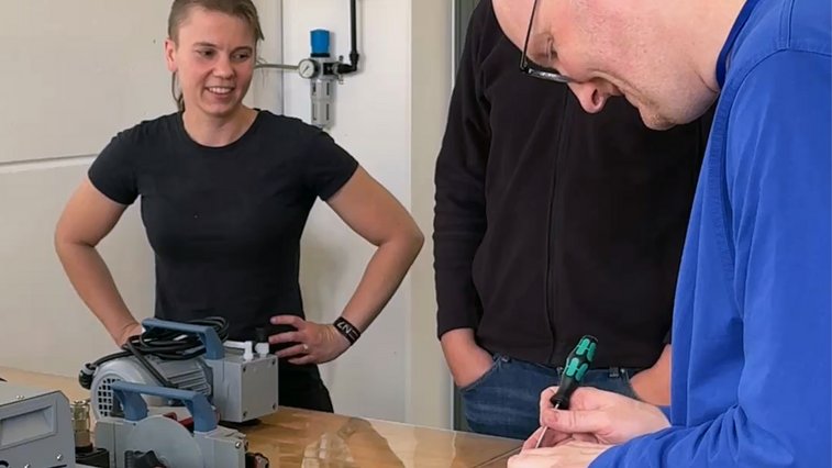 Seminar participants working hands-on with vacuum pumps